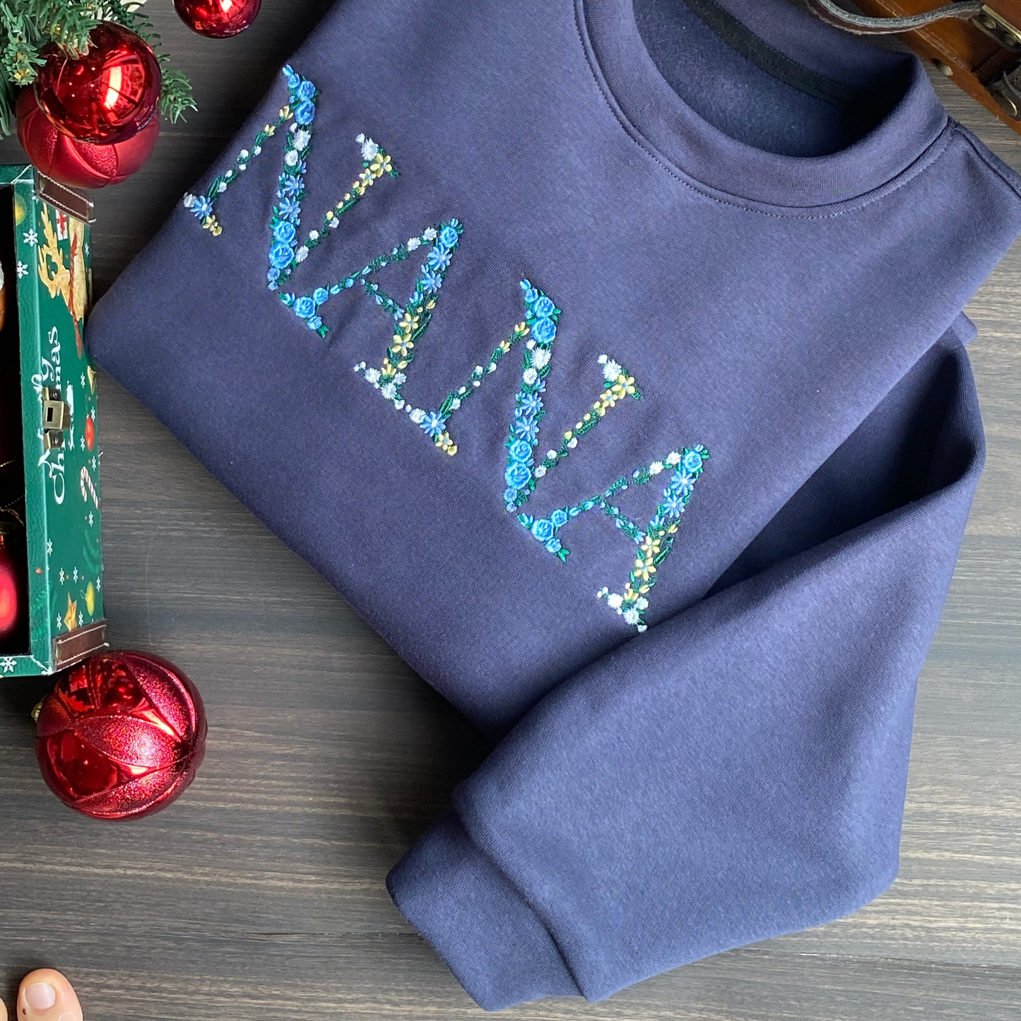 Mẫu thêu áo sweater chữ hoa NANA trên áo nỉ xanh navy, món quà ý nghĩa dành cho người phụ nữ tuyệt vời nhất