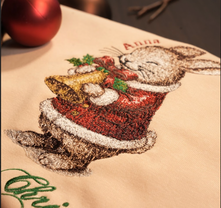 Mẫu thêu Giáng Sinh trên áo nỉ phối cùng chữ Merry Christmas và tên riêng tuỳ chỉnh.